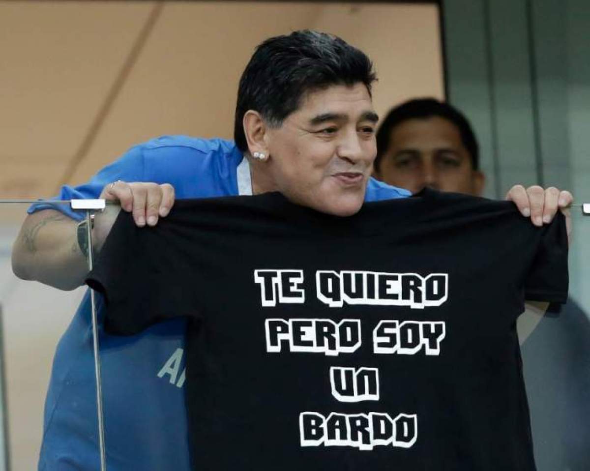 Diego Maradona, aflat la tribună, ține în mâini un tricou cu o inscripție