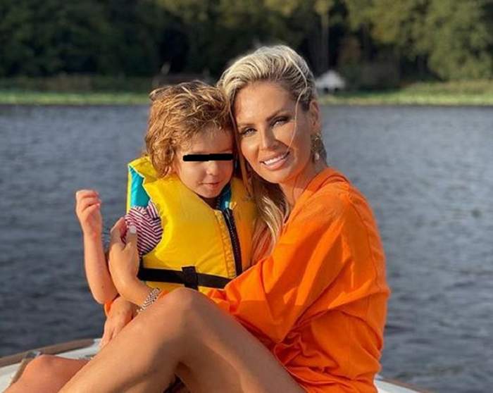 Andreea Bănică își ține în brațe fiul. Cei doi sunt pe un lac.