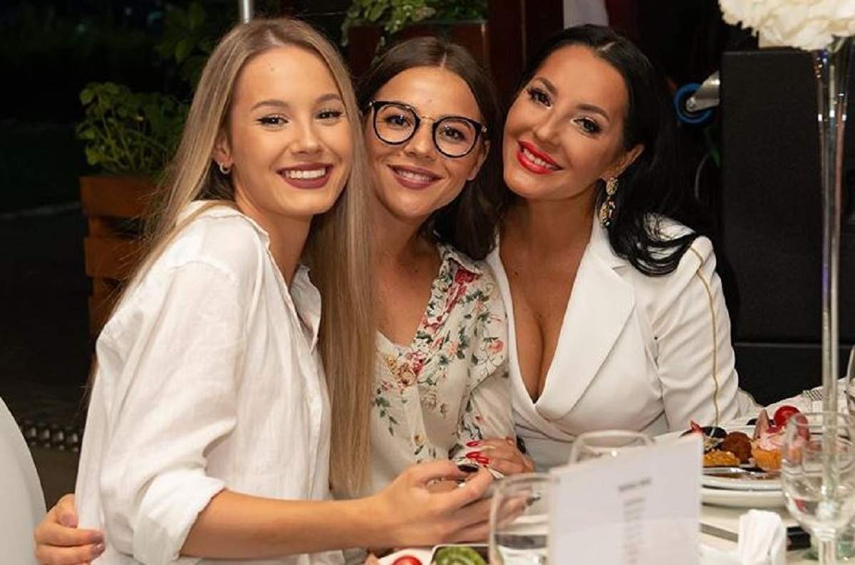 Angela Rusu și fiicele sale, Rebeca și Larisa. Cele trei stau la masă și sunt îmbrăcată în ținute albe