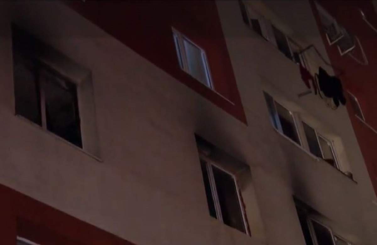 Blocul este afectat din cauza incendiului, se observa urmele de fum pe fereastra apartamentului
