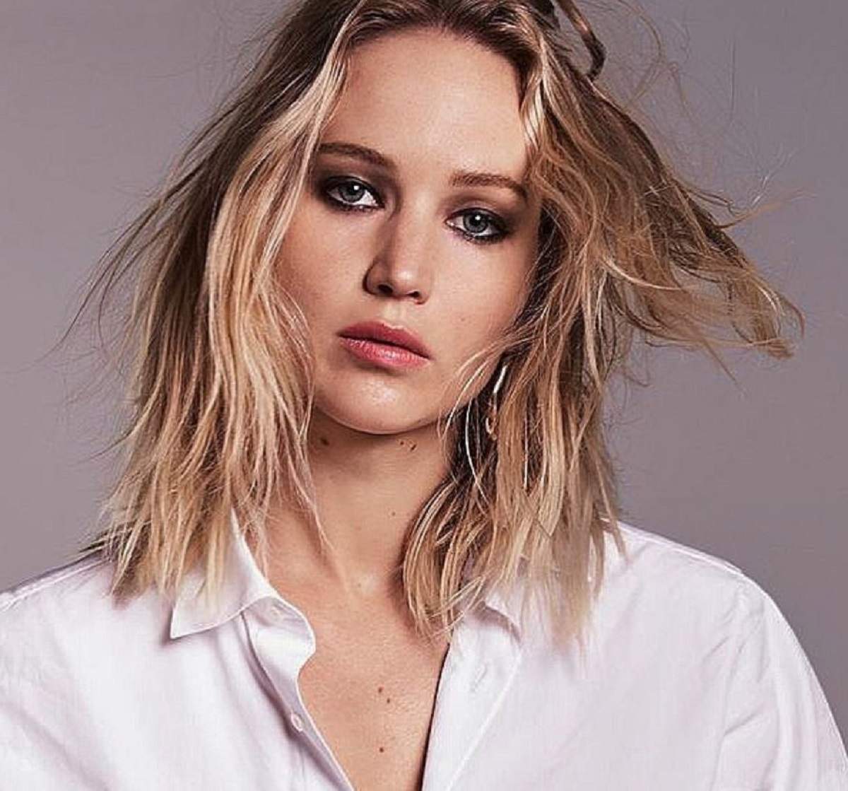 Jennifer Lawrence pozeaza intr-un editorial, are parul desprins si nearanjat si are o camasa alba