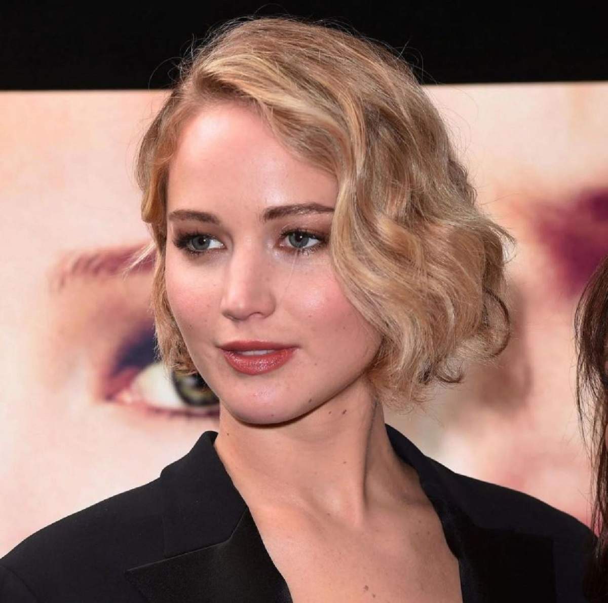 Jennifer Lawrence este pe covorul rosu, poarta o tinuta neagra