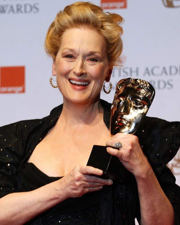 Meryl Streep este pe covorul rosu si tine in maini un premiu castigat