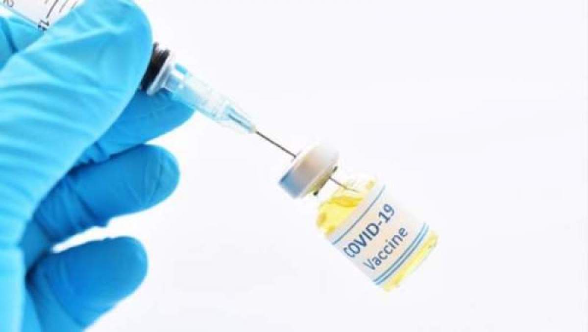 Fotografie ilustrativă, cu mâna unui medic care ține o sringă și o sticluță de vaccin anti-COVID-19