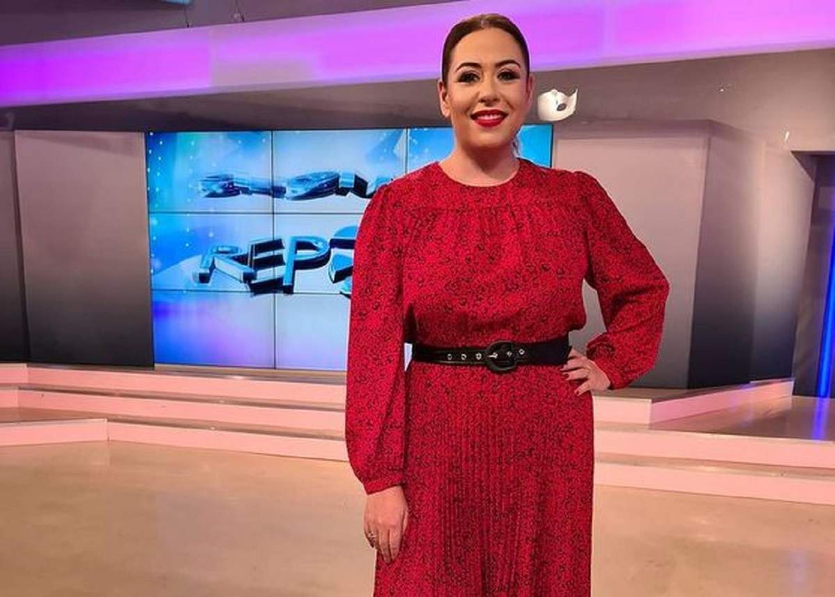 Oana Roman se află la Antena Stars. Vedeta e îmbrăcată cu o rochie roșie și își ține mâna în șold.