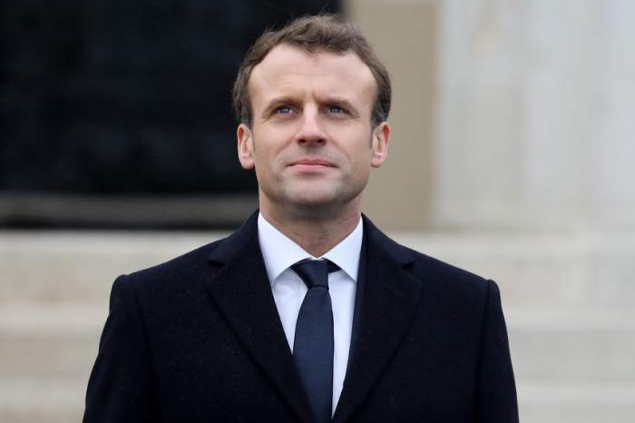 Emmanuel Macron este in fata unei cladiri, poarta costum cu cravata albastra