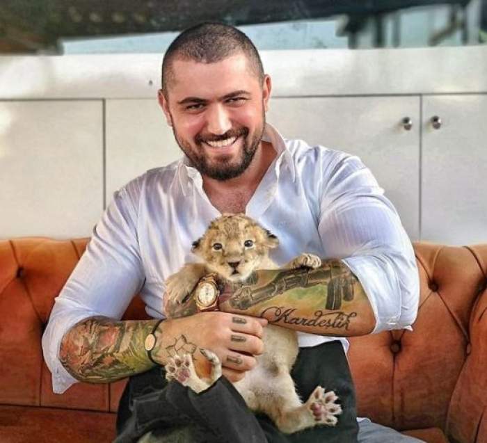 Cengiz Şıklaroğlu s-a fotografiat îmbrăcat elegant cu un pui de leu în brațe