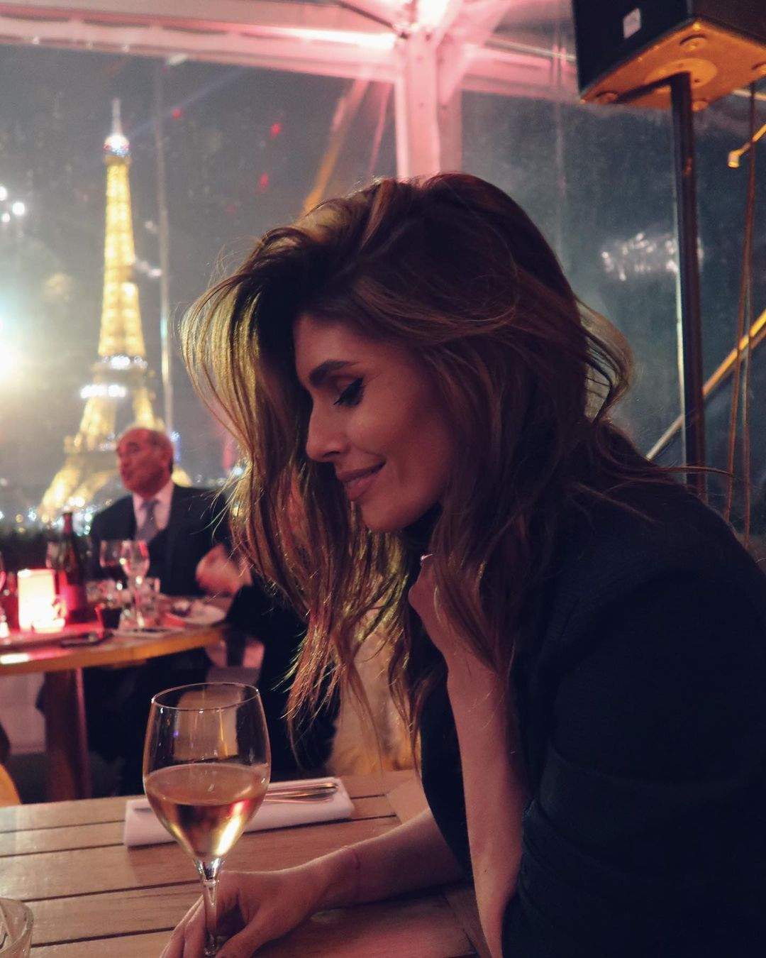 Sanziana Negru este la o cafenea din Paris, are un pahar cu vin alb in fata si zambeste