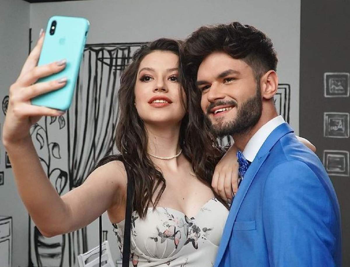 Cleopatra Stratan și Edward Sanda își fac un selfie. Ea poartă un top alb cu fluturi, iar el un costum bleu.