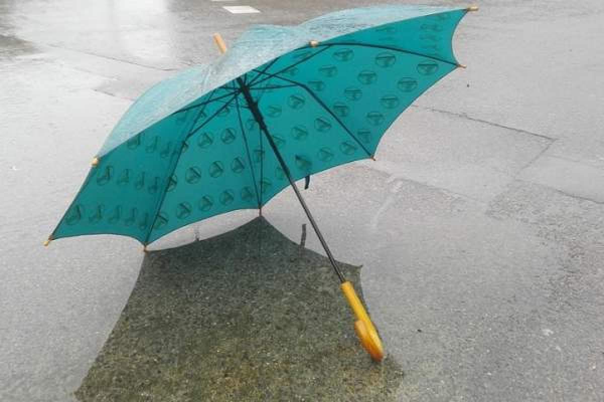O umbrelă albastră, pe o stradă plouată