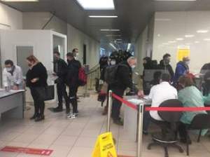 Sute de români se întorc din Anglia și sunt trimiși direct în carantină. Imagini de la Aeroportul Otopeni / VIDEO