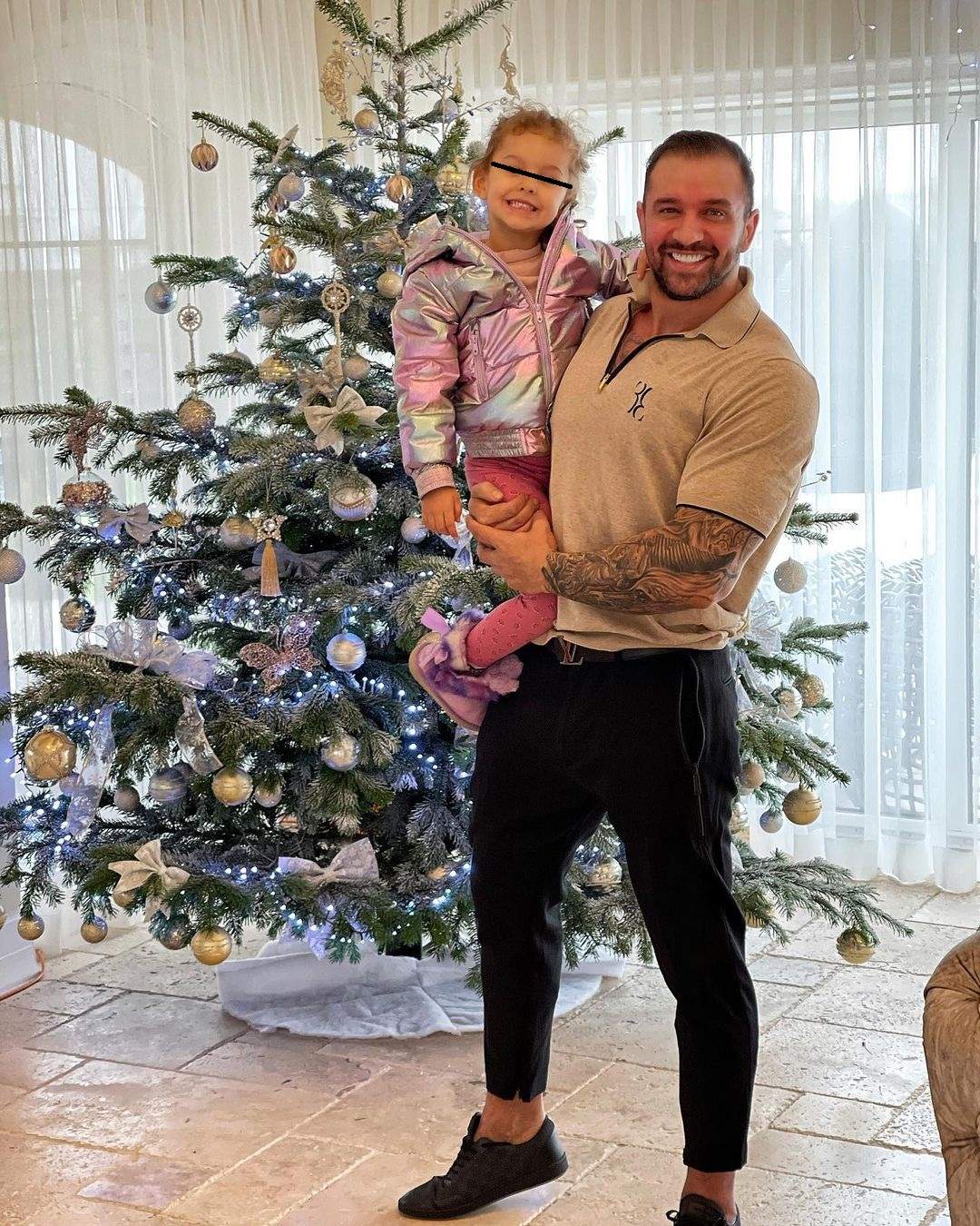 Alex Bodi și fiica sa lângă bradul de Crăciun.