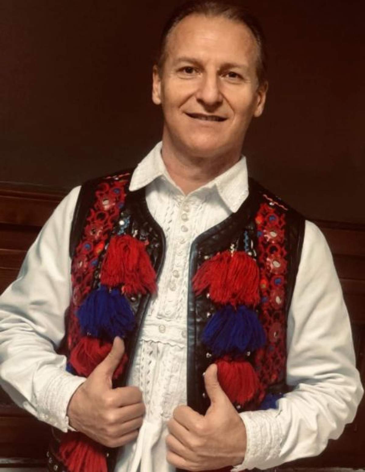 Dinu Iancu Sălăjanu, fotografiat zâmbitor, în costum tradițional popular
