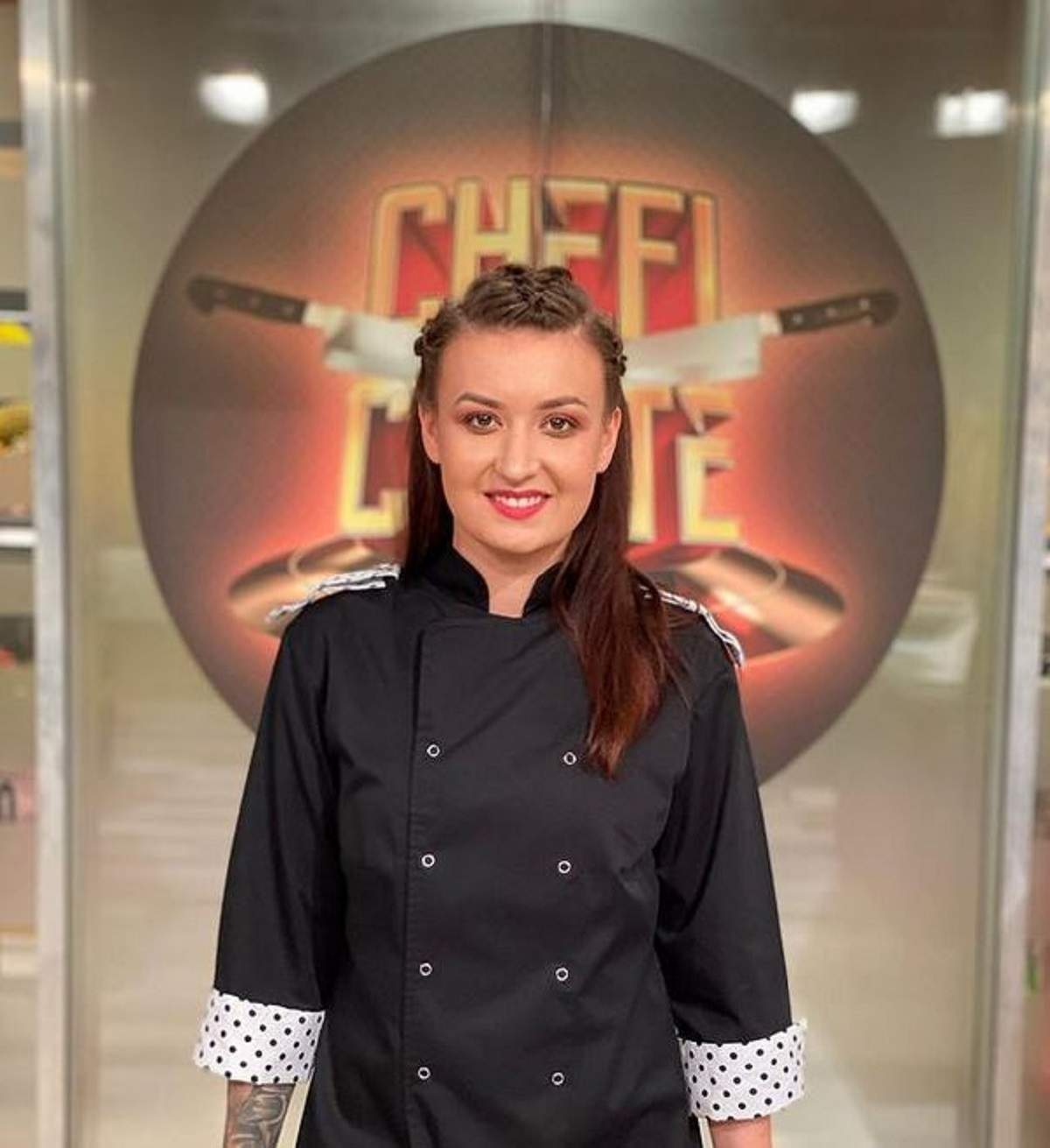 Roxana Blenche se află la „Chefi la Cuțite”. Concurenta zâmbește larg și e îmbrăcată în uniformă de bucătar.