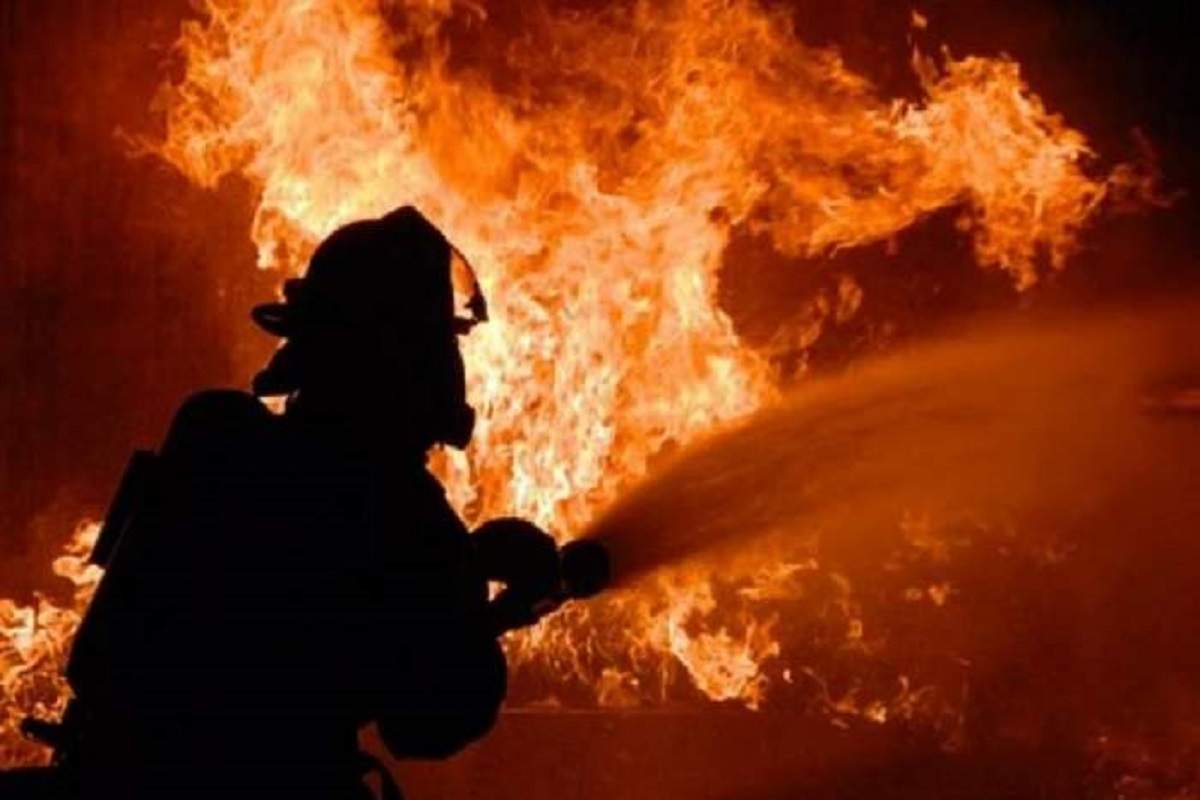 Imagine cu un pompieri in timp ce stinge un incendiu