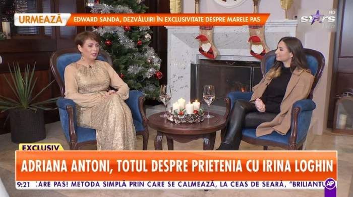 Adriana Antoni stă pe un fotoliu albastru. Artista e îmbrăcată într-o rochie crem și dă un interviu pentru Antena Stars.