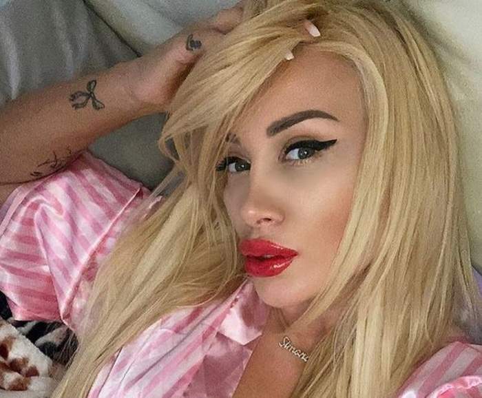 Simona Trașcă se află în pat. Vedeta poartă o pijama roz și își ține mâna prin șuvițele de păr blonde.