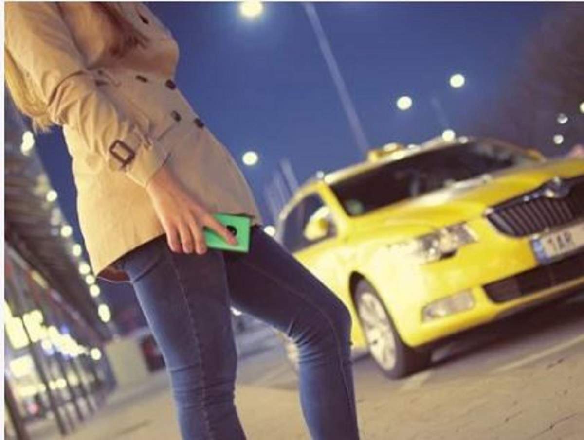 O clientă solicită o cursă cu un taxi prin intermediul unei aplicații online de pe telefonul mobil