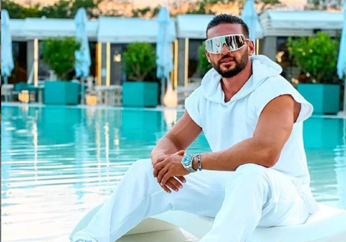 Dorian Popa s-a fotografiat pe marginea unei piscine, într-o ținută complet albă, asortată cu ochelari de soare masivi