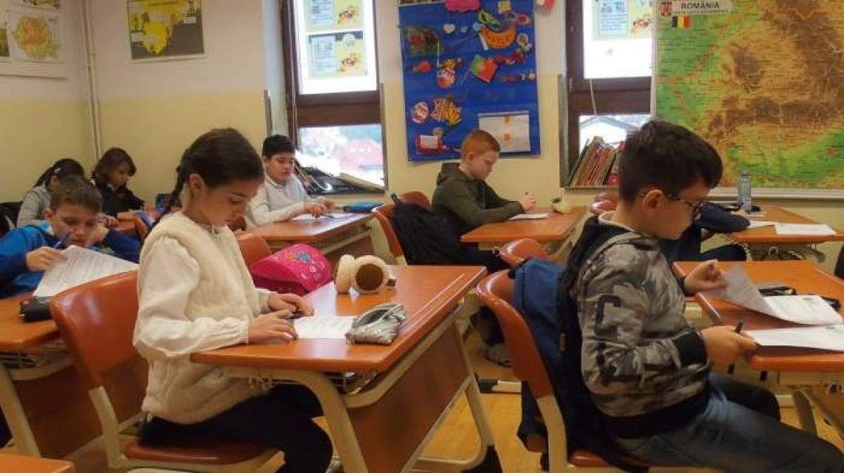 Mai mulți elevi se află în sala de curs, în timpul unui test