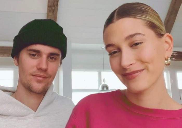 Hailey Baldwin într-o bluză roz, alături de Justin Bieber într-un hanorac alb și cu un beanie negru, în casa lor din Beverly Park