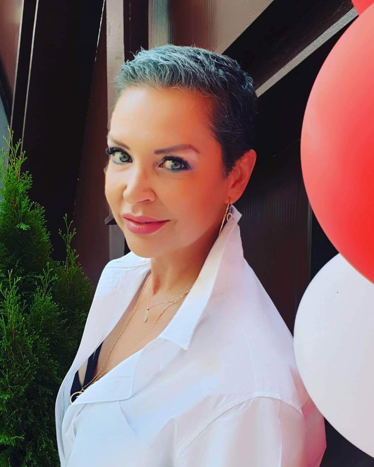 Eugenia Șerban, tunsă scurtă, zâmbitoare și purtând o cămasă albă, după ce a învins cancerul