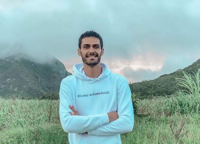 George Burcea este ka munte, pozează cu panorama în spate și poartă un hanoorac albastru