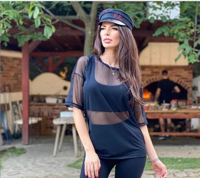 Ioana Filimon este la un restaurant, poartă o pălărie de culoare neagră, un tricou transparent, un top scurt negru, asortat cu pantaloni de aceeași culoare