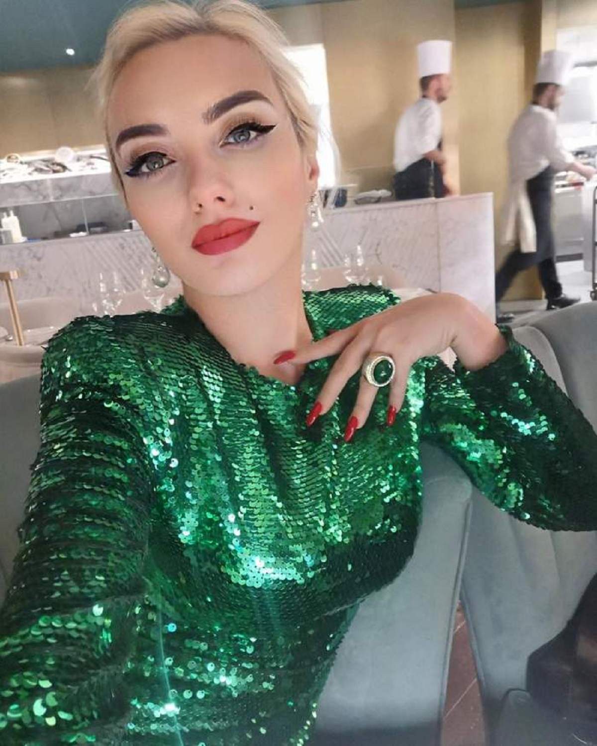 Ana Morodan și-a făcut un selfie, poartă o rochie verde cu paiete, are părul prins și-și ține mâna dreaptă pe piept