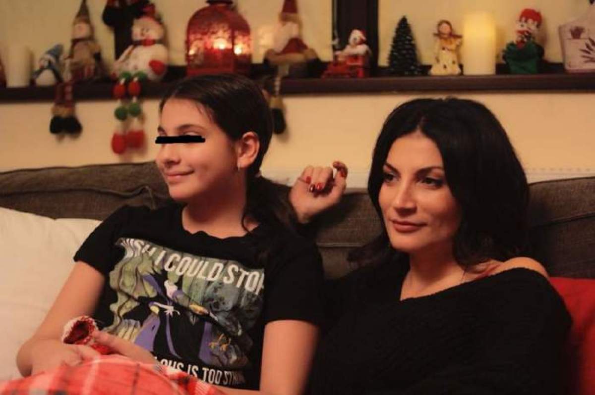 Ioana Ginghină și fetița sa, îmbrăcate în negru, stau pe canapea, zâmbitoare