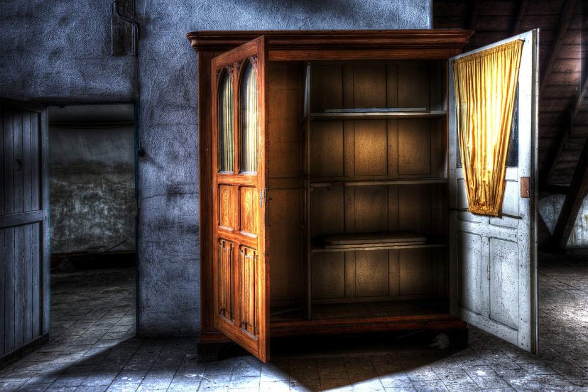 Poză editată cu un dulap gol cu ușile deschise, într-o casă abandonată