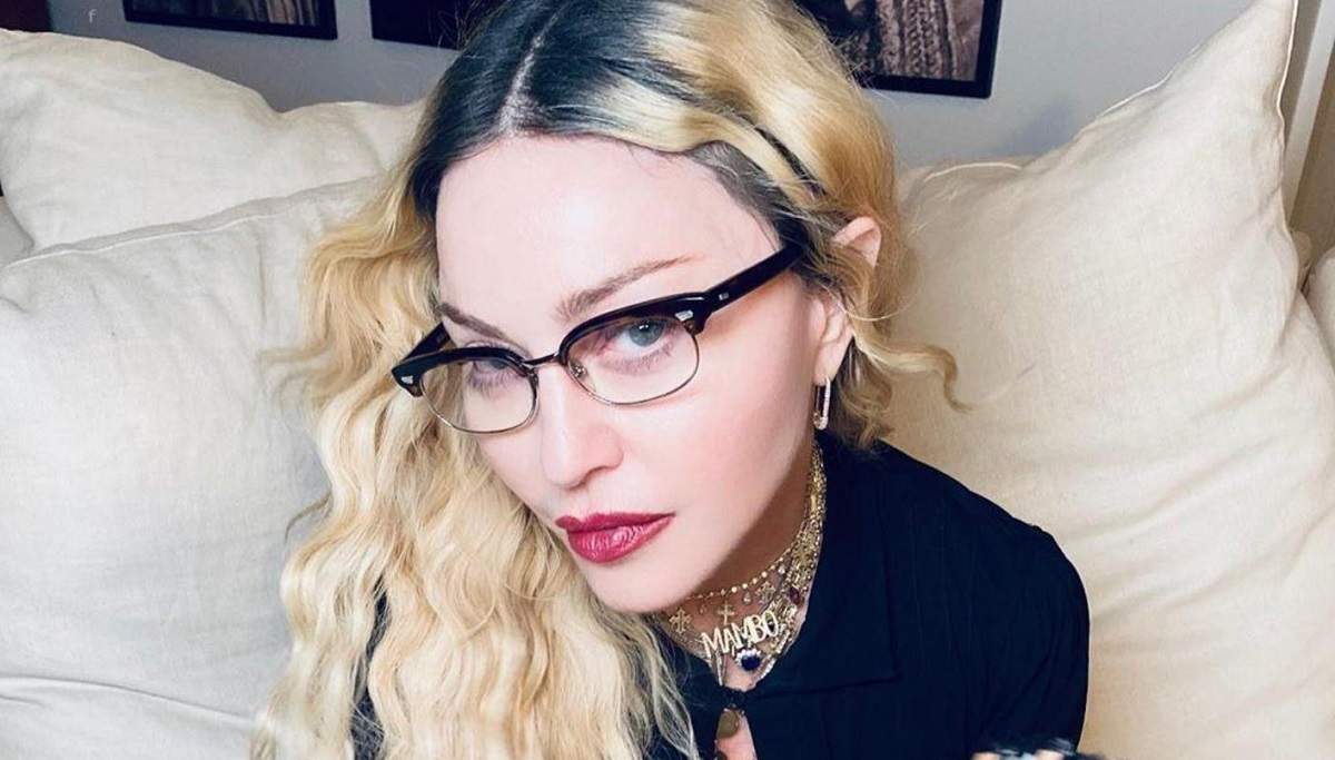 Madonna pozează pe pat, cu un evantai și ochelari, poză postată pe Instagram pe 13 septembrie 2020