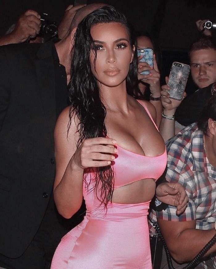 Kim Kardashian este la un eveniment, poarta o rochie mulata si decoltata roz