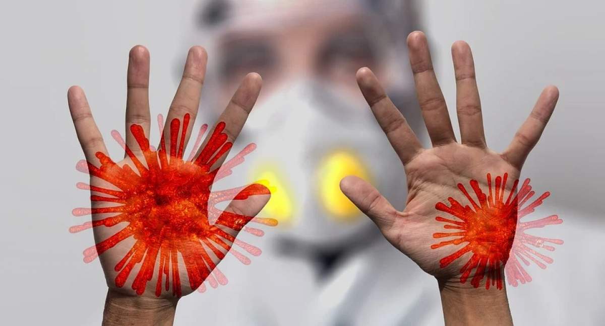 Bărbat cu mască și palmele infectate cu virus