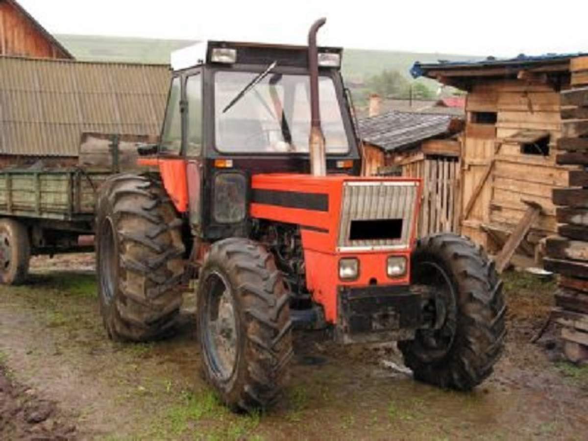 Un tractor cu o remorcă în curtea unei case, ilustrând tragedia din Bihor