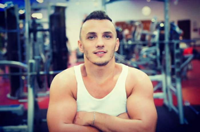 Mihai Trăistariu este la sala de fitness, cu un top alb prin care i se vede corpul lucrat