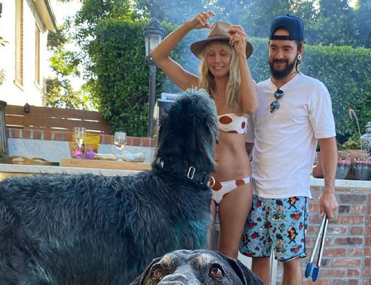 Heidi Klum poartă un costum de baie alb, în buline roșii. Lângă ea este soțul ei, Tom Kaulitz.