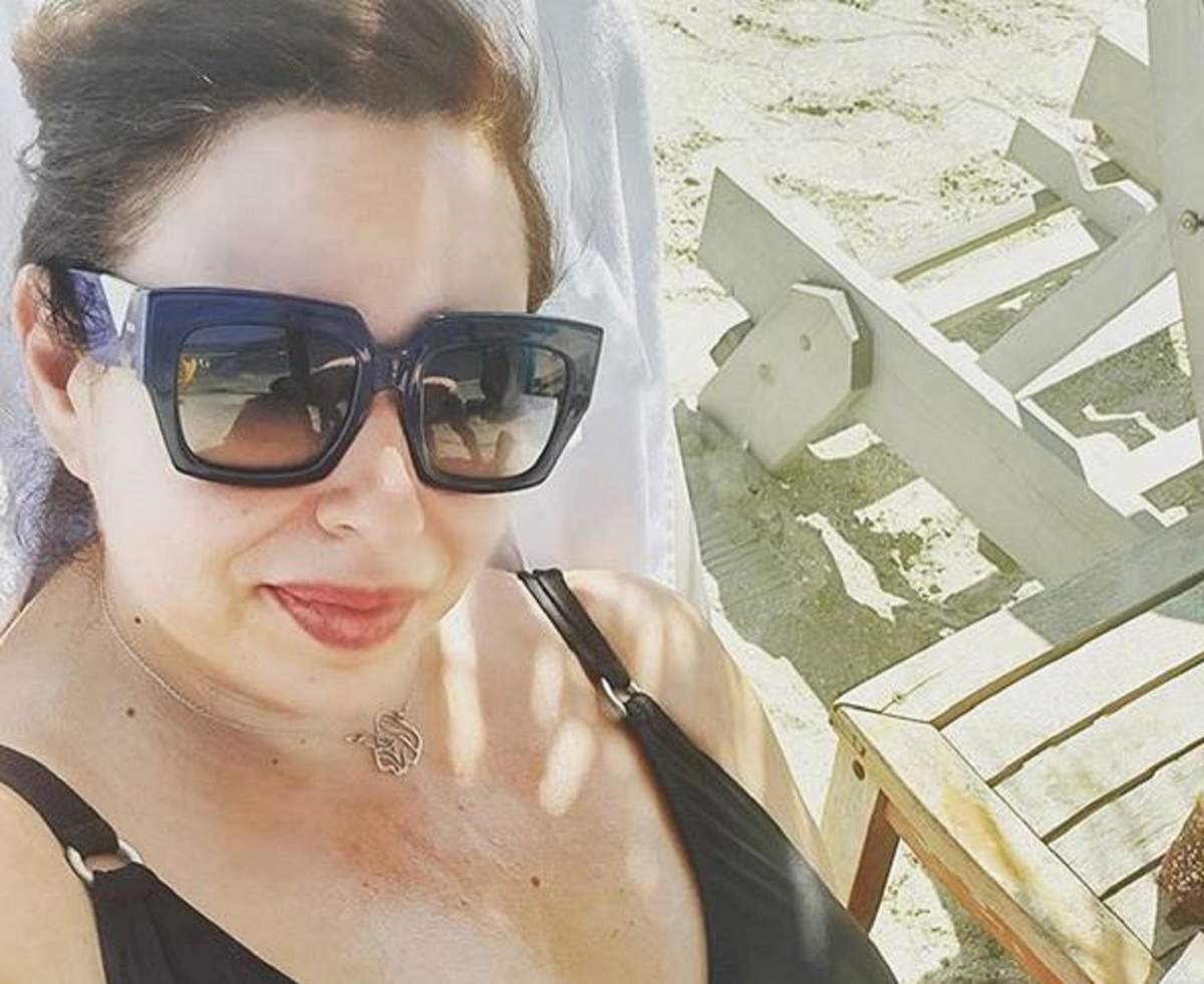 Oana Roman la plajă. Vedeta poartă ochelari de soare și un costum de baie negru