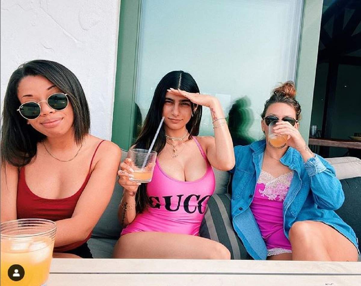 Mia Khalifa si prietenele ei, stau la o masa, in costume de baie si beau alcool