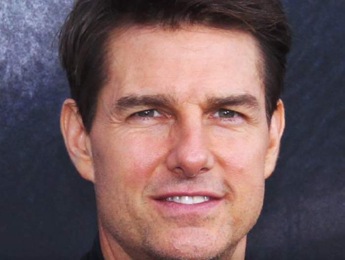 Tom Cruise in cadrul unui eveniment, zambeste timid