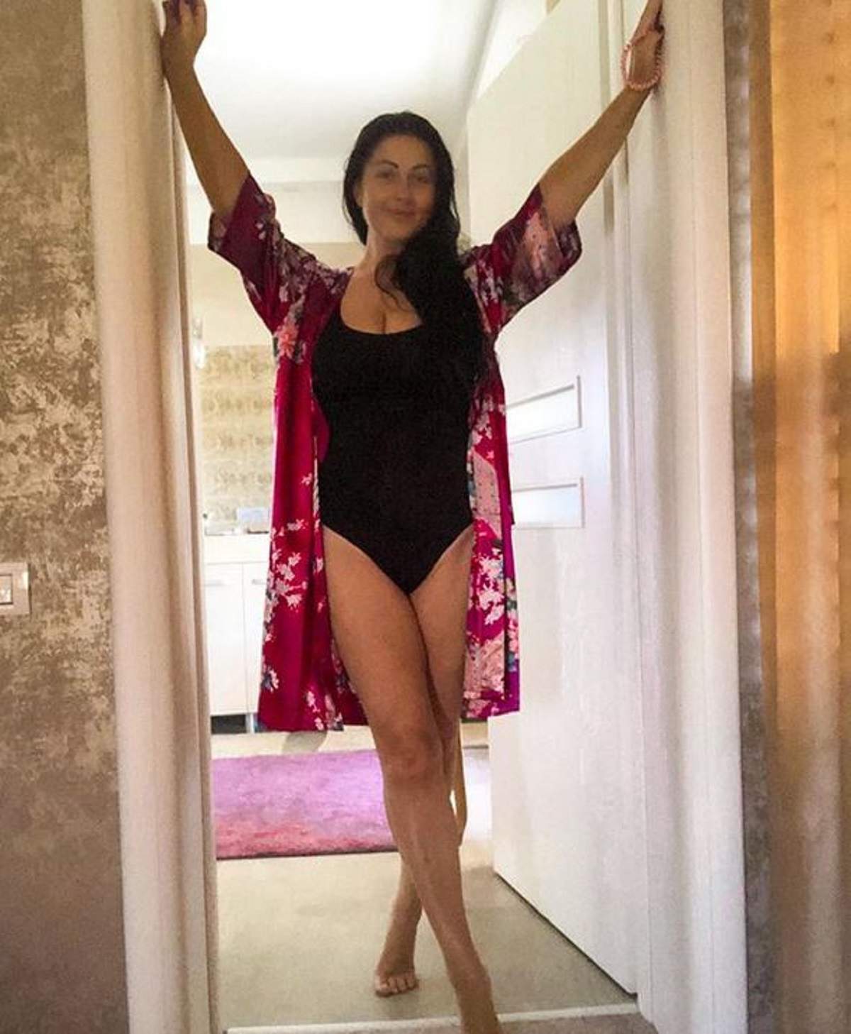 Gabriela Cristea poartă un body negru. Pe deasupra, vedeta are o rochie descheiată, roz și înflorată.