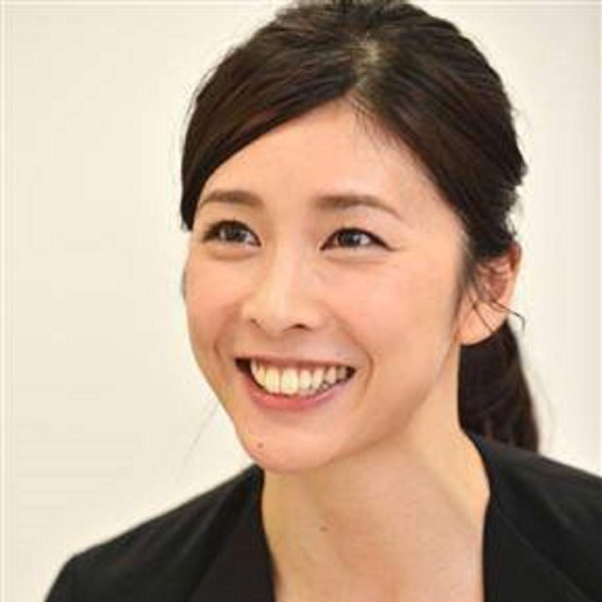 Actrita Yuko Takeuchi are parul prins, o bluza neagra si zambeste larg