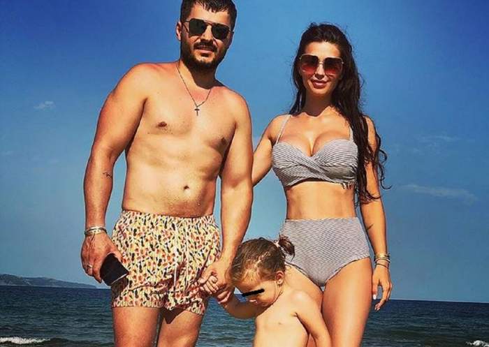 Anda Călin și Liviu Vârciu sunt alături de fiica lor la mare. Ea portă un costum de baie gri și artistul un short scurt.