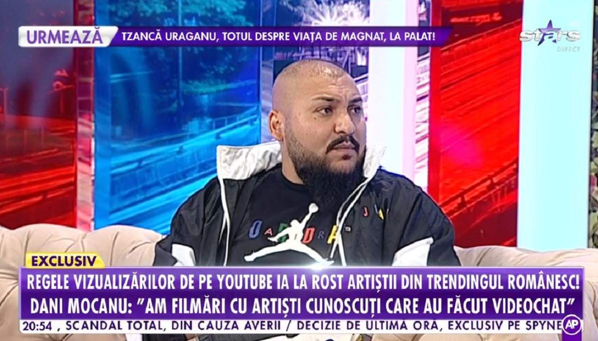 Dani Mocanu stă pe canapea. Artistul poartă un trening negru.