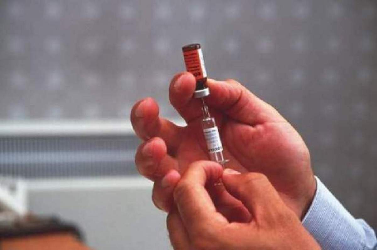 O seringă extrage din fiolă vaccinul
