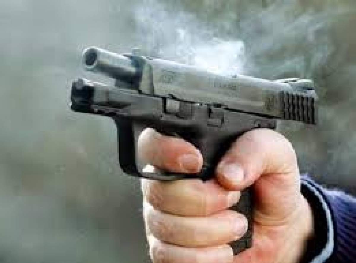 Fotografie cu un pistol ținut în mână de un bărbat