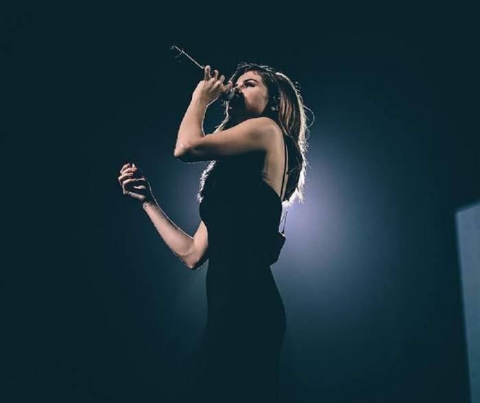 Selena Gomez cântă pe scenă, în tunrenul sau international