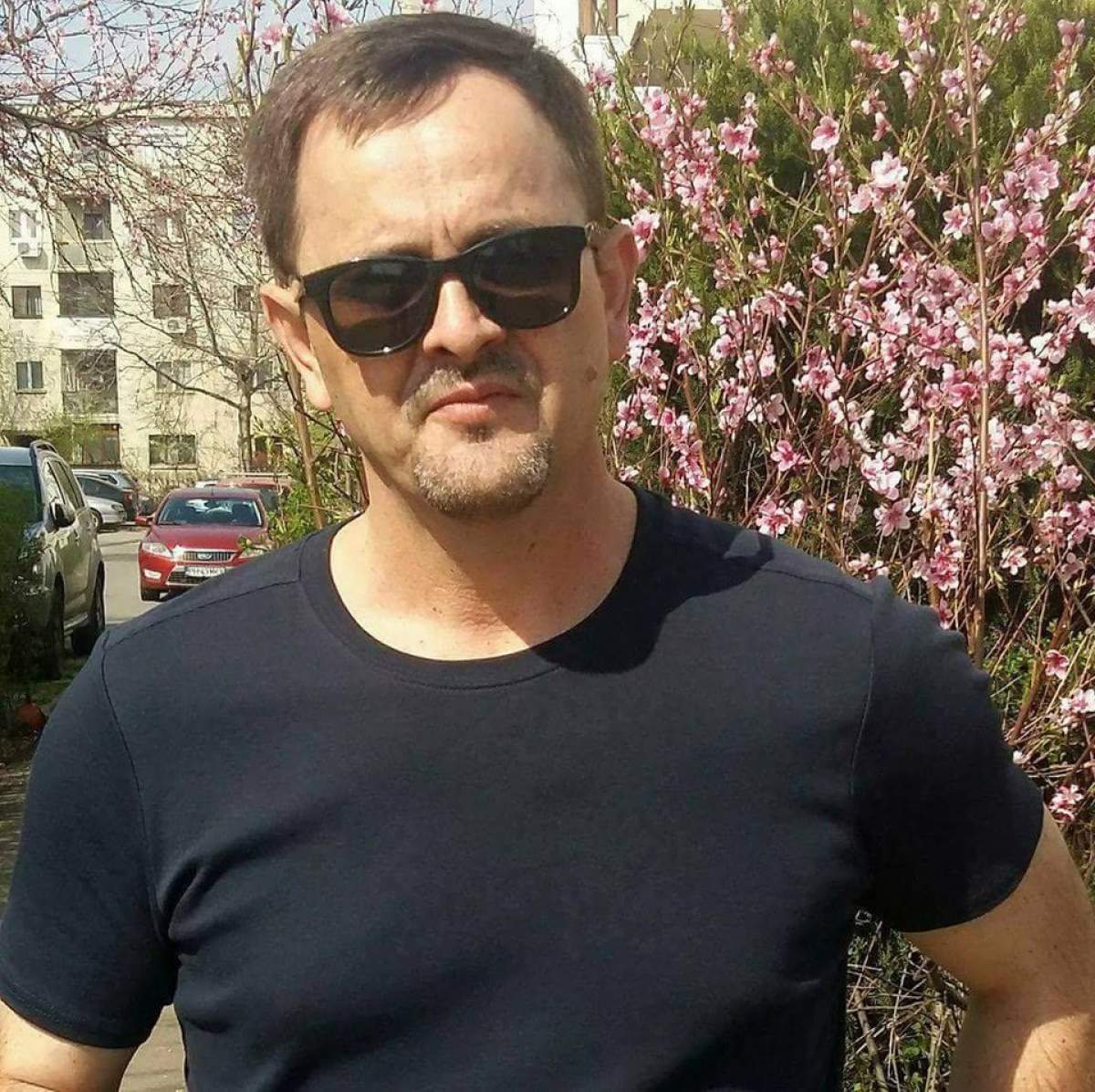 marian manole cu tricou negru şi ochelari de soare pe stradă