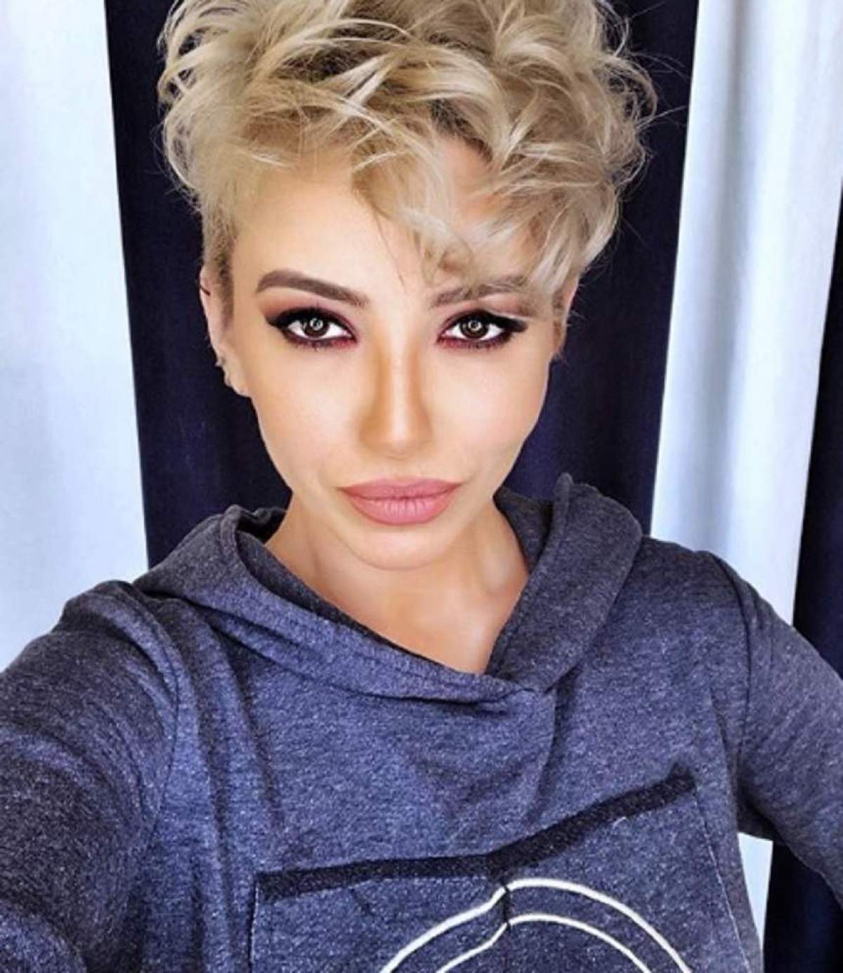 Giulia Anghelescu și-a făcut un selfie, în bluza albastră, tunsă scurt, blondă și foarte machiată