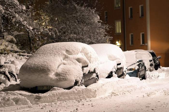 Mașini parcate acoperite cu un strat mare de zăpadă